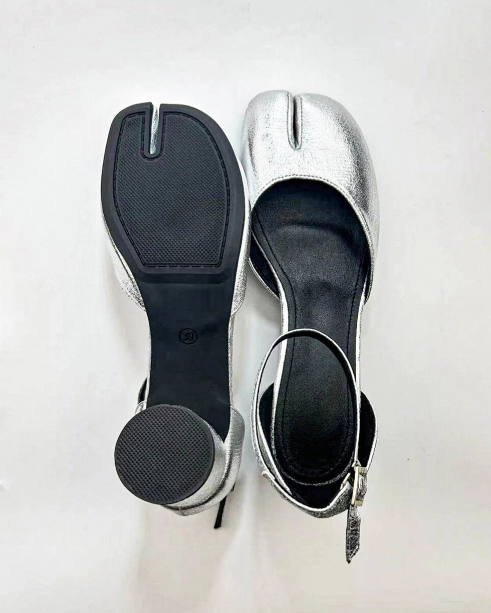 A pair of silver Tabi ankle strap sandal pumps with a heel and microfiber leather lining.